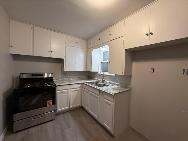 1234 N Travis St, Sherman, TX 75092 - kitchen with stainless steel range with gas stovetop, a sink, wood finished floors, light countertops, and white cabinets