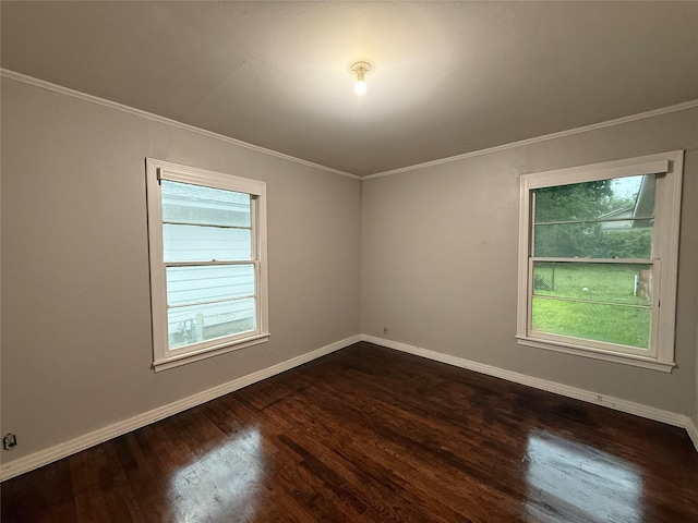 spare room with dark wood-type flooring, baseboards, and ornamental molding