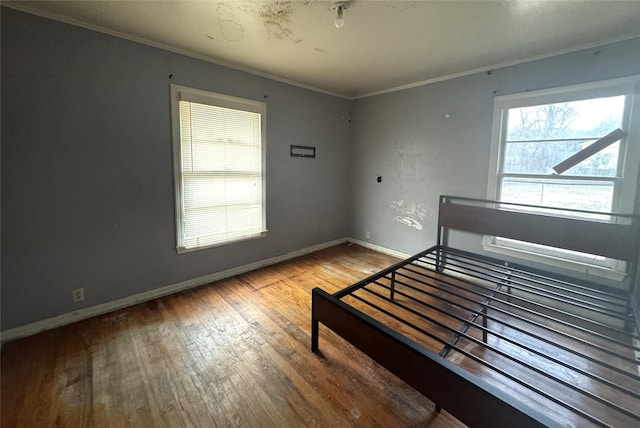 unfurnished bedroom featuring ornamental molding and wood-type flooring