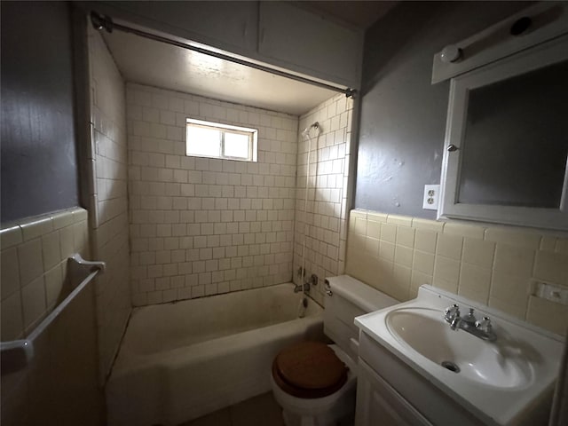 full bathroom with tile walls, tiled shower / bath combo, vanity, decorative backsplash, and toilet