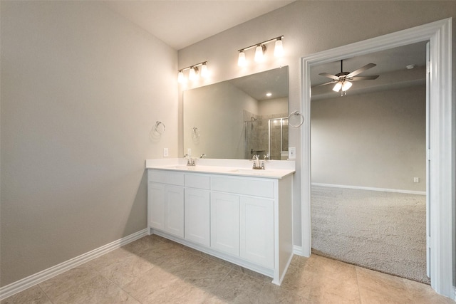 bathroom featuring ceiling fan, vanity, a shower with door, and tile patterned floors