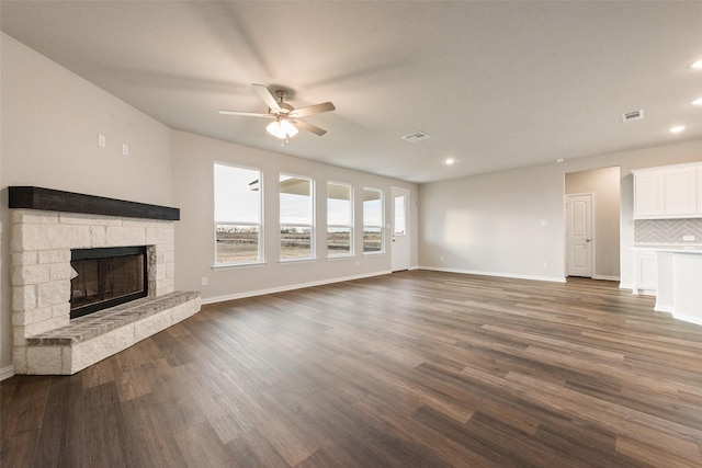 unfurnished living room with ceiling fan, a fireplace, and dark hardwood / wood-style flooring