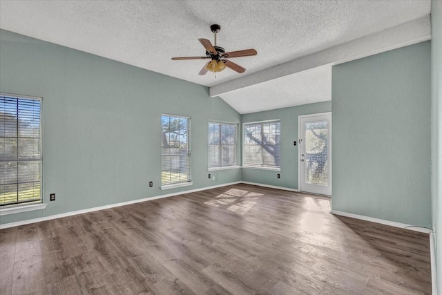 empty room featuring ceiling fan, a textured ceiling, vaulted ceiling, and wood-type flooring