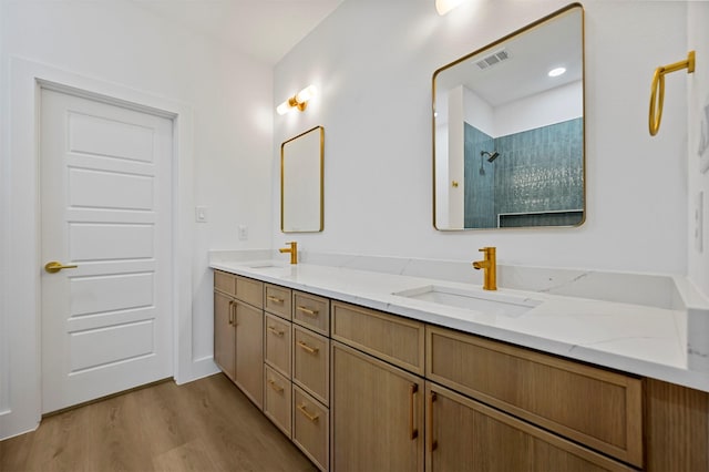 bathroom featuring vanity, hardwood / wood-style floors, and a shower