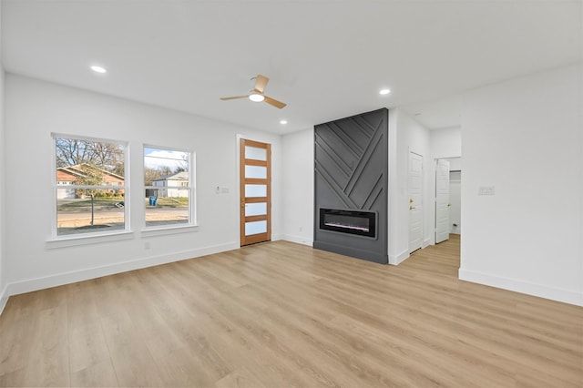 unfurnished living room with a fireplace, light hardwood / wood-style floors, and ceiling fan