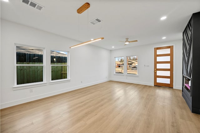 unfurnished living room with ceiling fan and light wood-type flooring