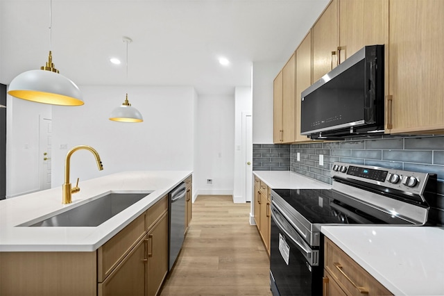 kitchen with decorative light fixtures, sink, decorative backsplash, light hardwood / wood-style floors, and stainless steel appliances