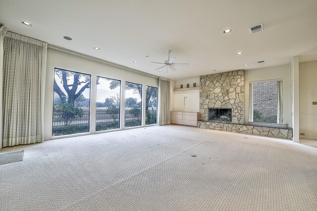 living room with ceiling fan, light colored carpet, and a fireplace