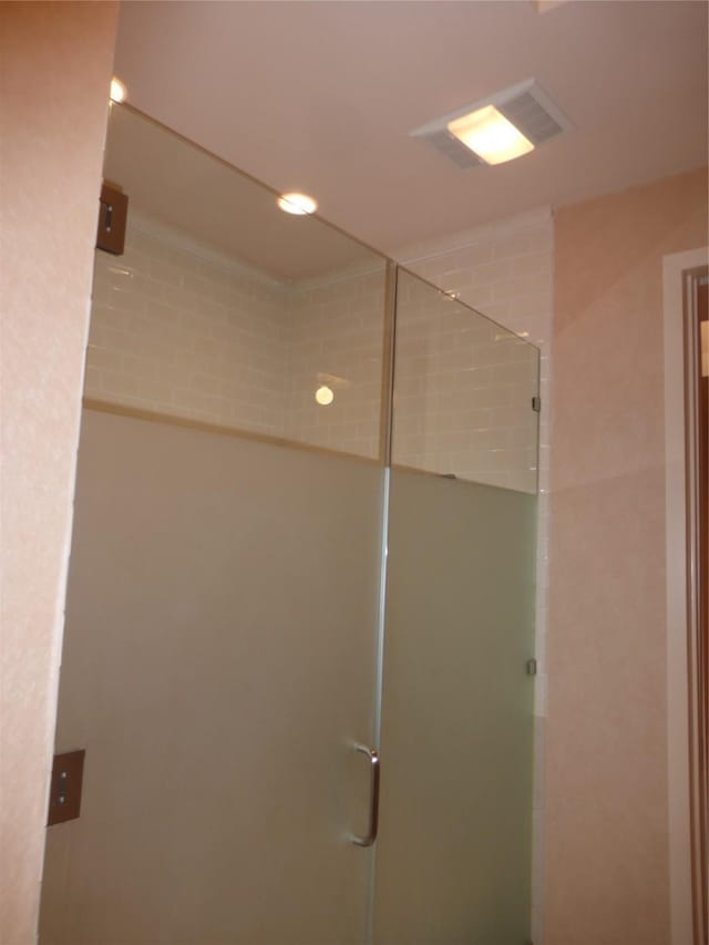 bathroom with a shower with door