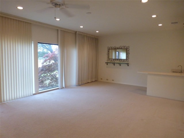 empty room featuring light colored carpet and ceiling fan