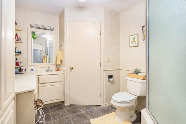 bathroom featuring vanity, walk in shower, and toilet