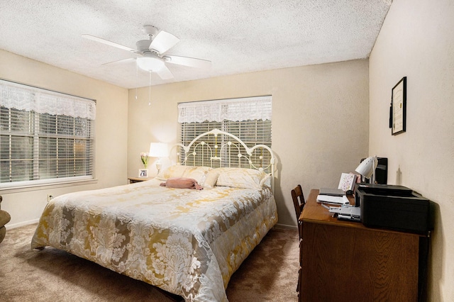 bedroom featuring ceiling fan, a textured ceiling, and dark colored carpet