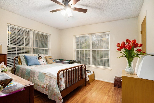 bedroom featuring a textured ceiling, ceiling fan, and light hardwood / wood-style flooring