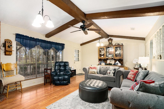 living room featuring lofted ceiling with beams, hardwood / wood-style flooring, and ceiling fan with notable chandelier