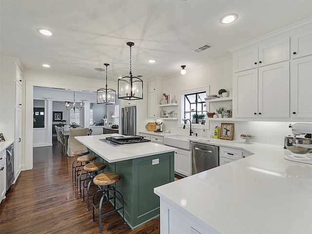 kitchen with appliances with stainless steel finishes, a kitchen breakfast bar, a center island, and white cabinets