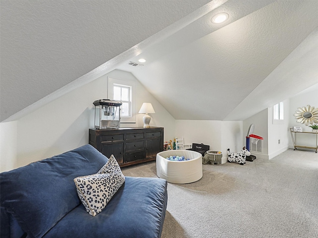 carpeted bedroom featuring lofted ceiling and a textured ceiling