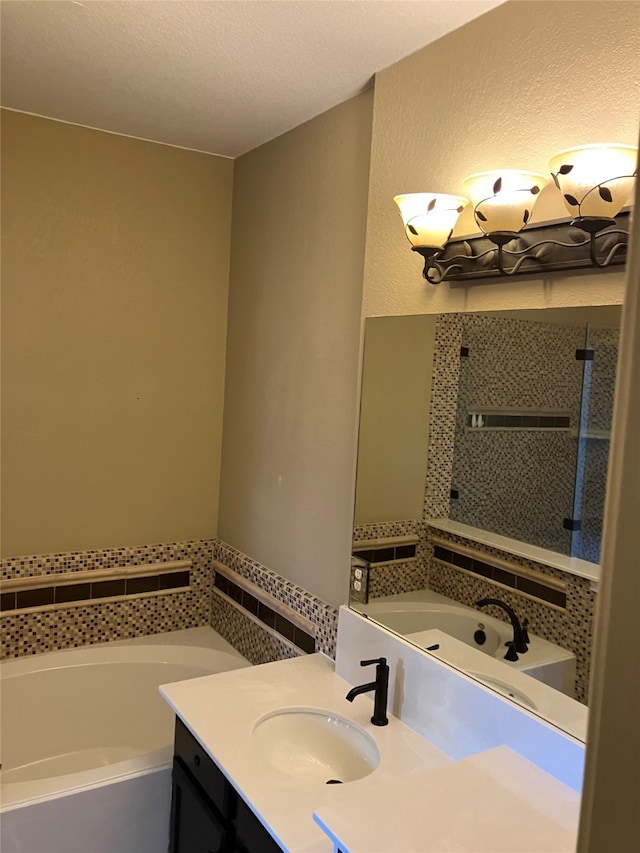 bathroom with vanity, a textured ceiling, and a washtub