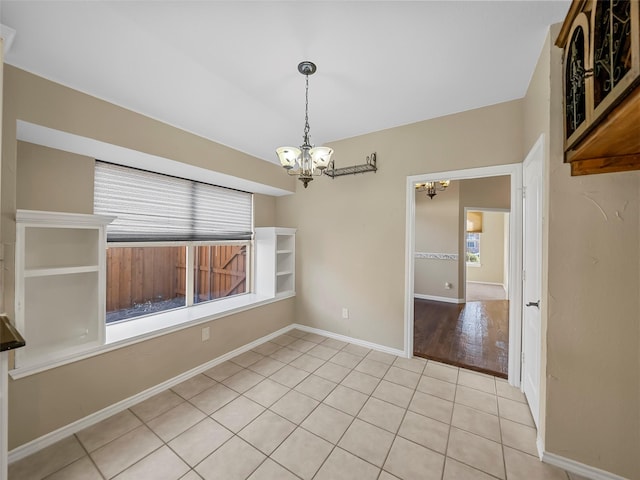 unfurnished dining area featuring light tile patterned flooring and an inviting chandelier