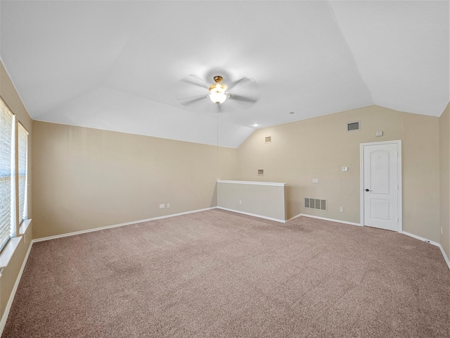 spare room featuring vaulted ceiling, carpet floors, and ceiling fan