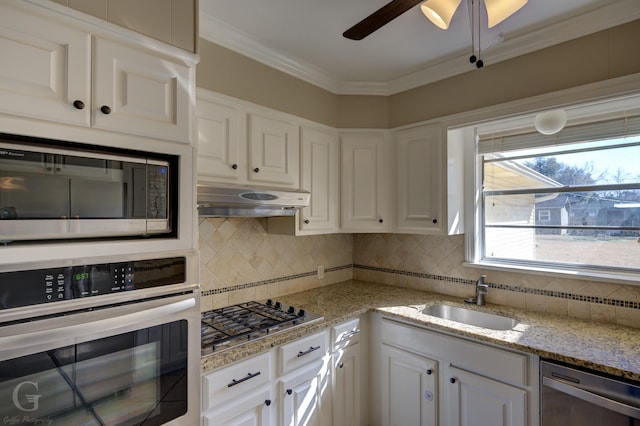 kitchen with sink, ornamental molding, white cabinets, and appliances with stainless steel finishes