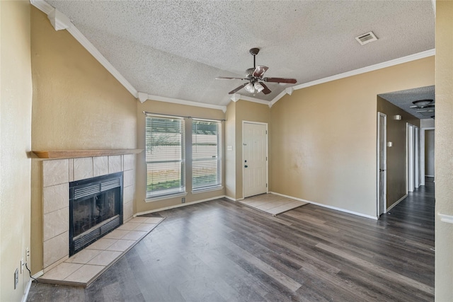 unfurnished living room featuring wood-type flooring, vaulted ceiling, ornamental molding, and a textured ceiling