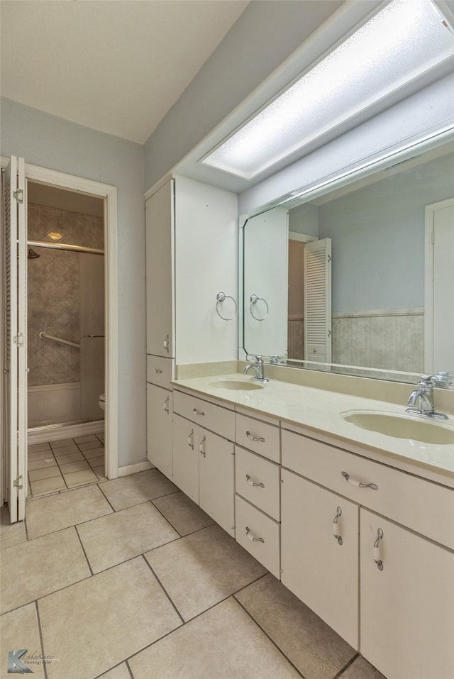 bathroom with vanity, tile patterned floors, toilet, and a tile shower