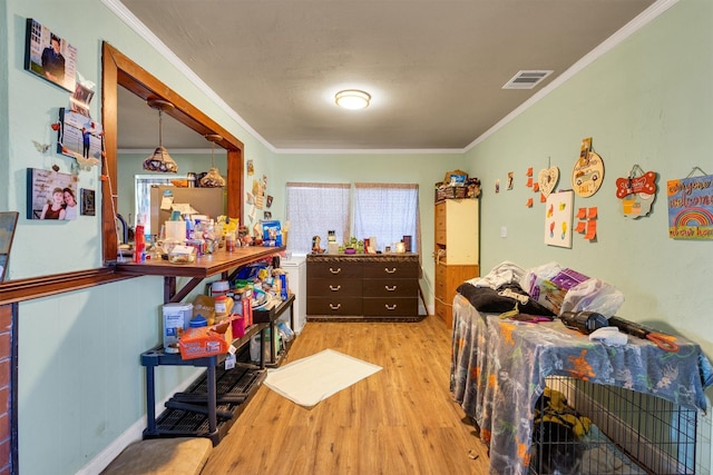 bedroom with ornamental molding and light hardwood / wood-style floors