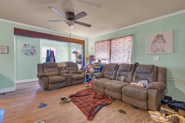 living room with ornamental molding, wood-type flooring, and ceiling fan