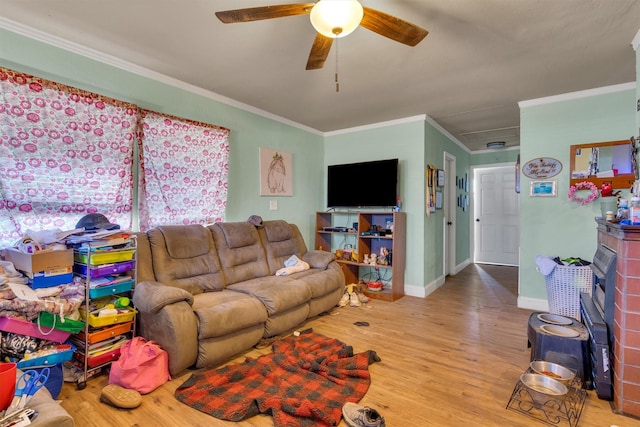 living room with a fireplace, crown molding, light hardwood / wood-style flooring, and ceiling fan