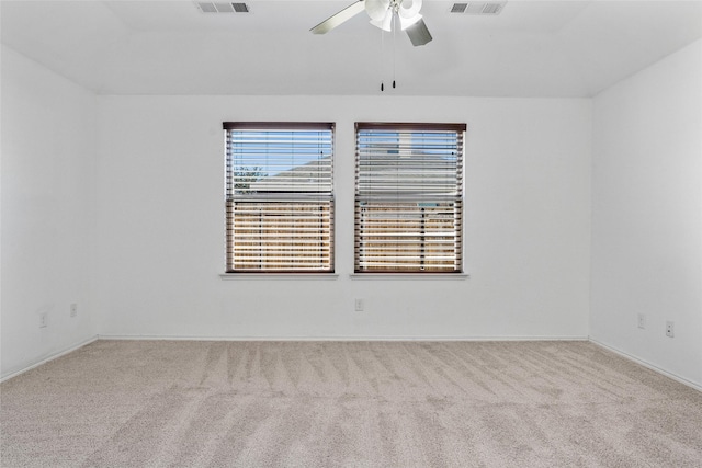 spare room with carpet, visible vents, and ceiling fan