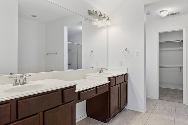 bathroom featuring tile patterned flooring, vanity, and a shower with door