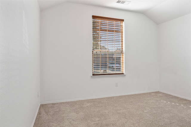 carpeted empty room featuring lofted ceiling