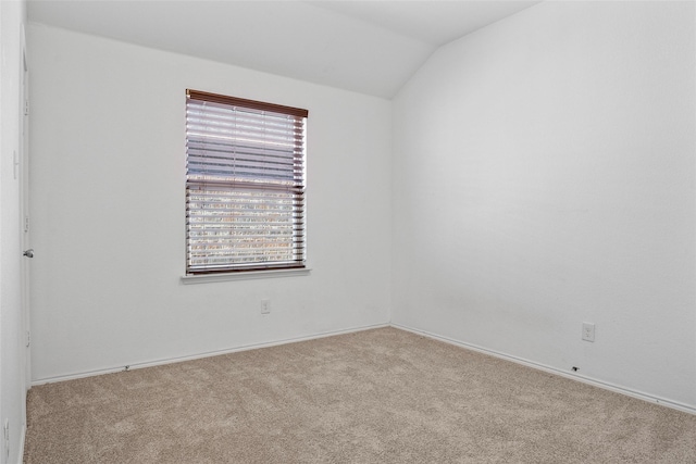 spare room featuring vaulted ceiling and carpet floors