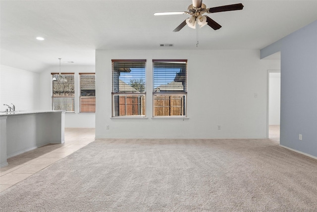 carpeted empty room with ceiling fan, lofted ceiling, and sink