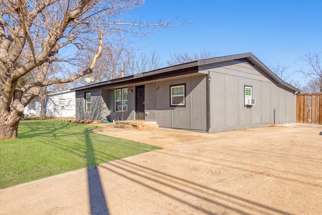 ranch-style home with cooling unit, a patio area, and a front yard