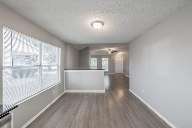 spare room with dark wood-type flooring, ceiling fan, and a textured ceiling