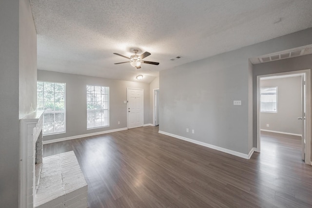 unfurnished living room with dark wood-type flooring, ceiling fan, and a textured ceiling