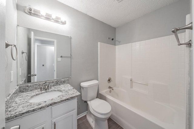 full bathroom with shower / bathing tub combination, wood-type flooring, vanity, toilet, and a textured ceiling