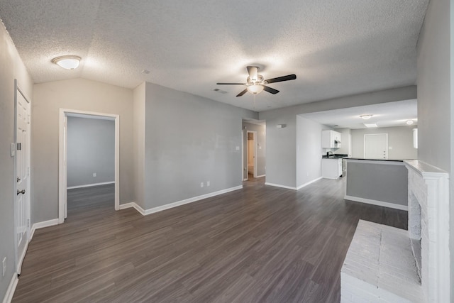 unfurnished living room with dark hardwood / wood-style flooring, a textured ceiling, and ceiling fan