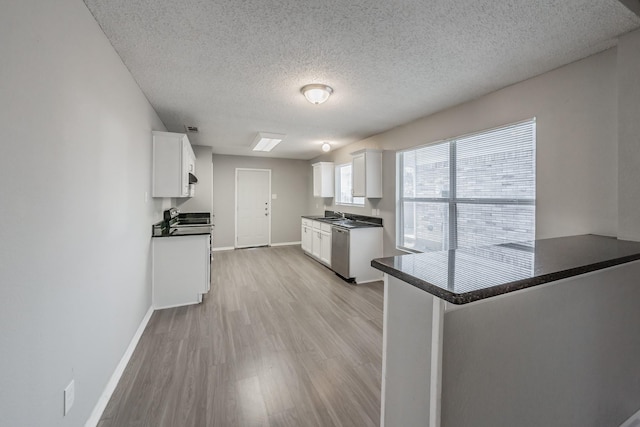 kitchen featuring light hardwood / wood-style flooring, stainless steel appliances, a textured ceiling, white cabinets, and kitchen peninsula