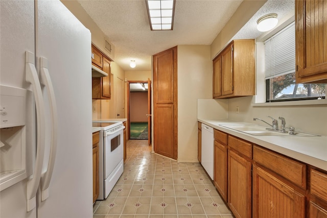 kitchen with sink, white appliances, and a textured ceiling