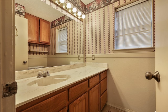 bathroom featuring tile patterned flooring, vanity, and toilet