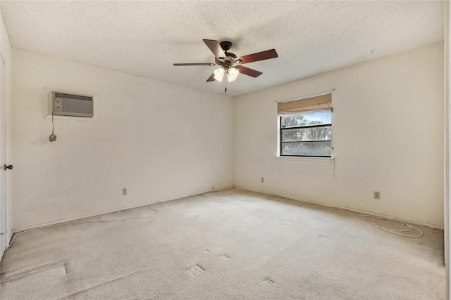 spare room featuring ceiling fan, light carpet, a wall mounted air conditioner, and a textured ceiling