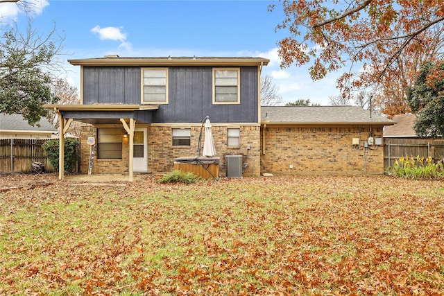 back of house with central AC and a yard