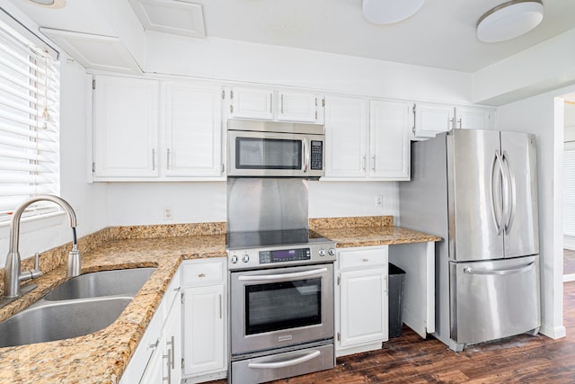 kitchen with sink, stainless steel appliances, white cabinets, and light stone countertops