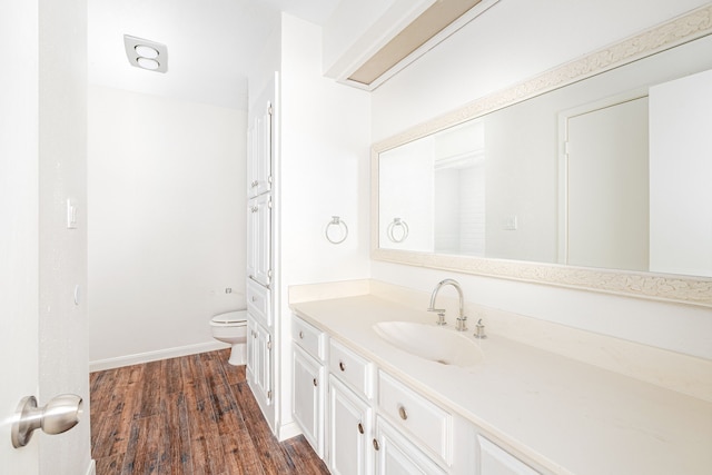 bathroom with vanity, hardwood / wood-style floors, and toilet