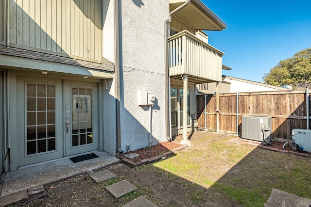 back of property featuring a balcony, central AC, and french doors