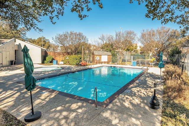 view of pool with a storage unit and a patio