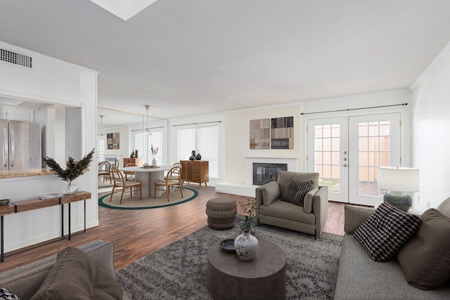 living room featuring hardwood / wood-style floors, crown molding, and french doors