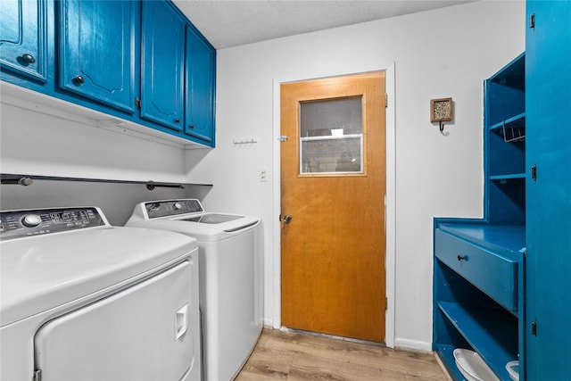 clothes washing area with cabinets, independent washer and dryer, and light hardwood / wood-style flooring